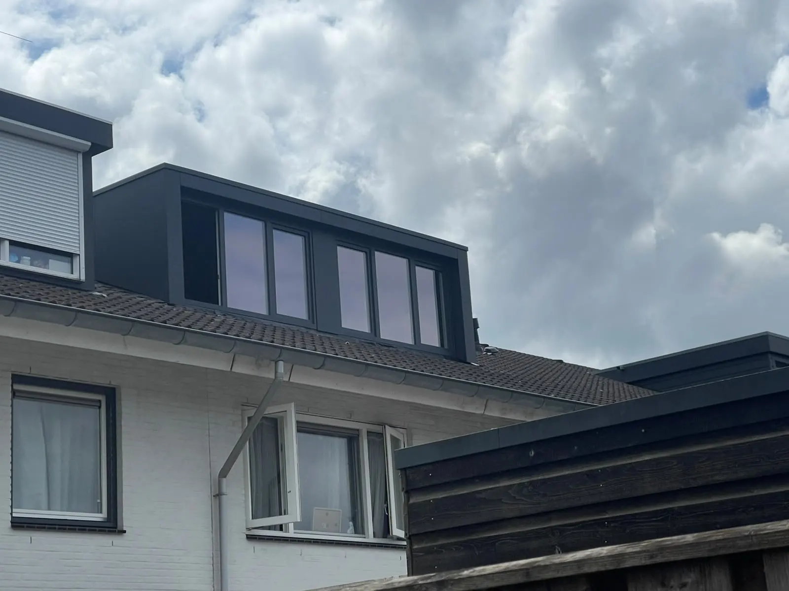 Antraciet dakkapel Vries op een witte woning