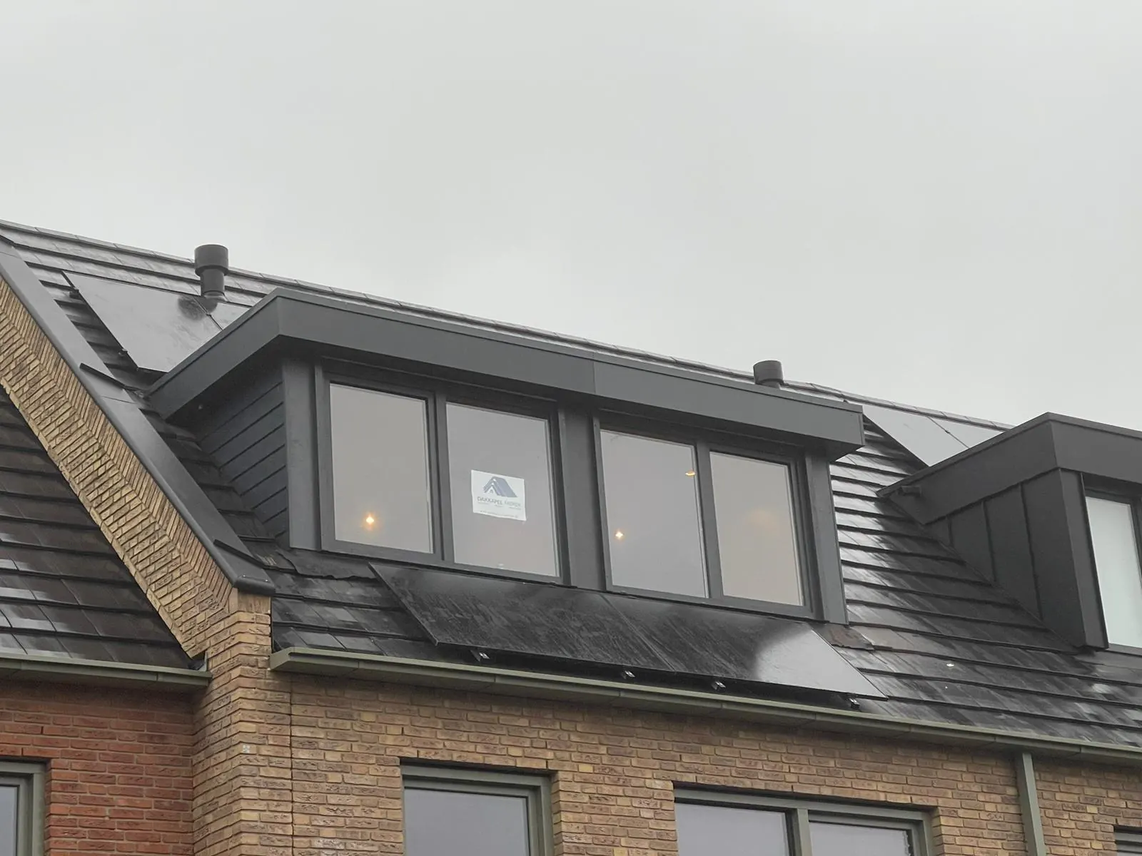 Zonnepanelen op de dakkapel: antraciet dakkapel tussen zonnepanelen