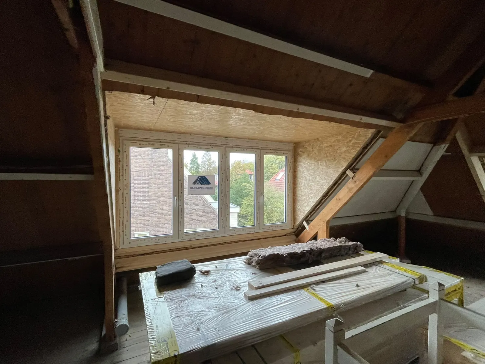 Hoekdakkapel in aanbouw: dakkapel met vier ramen in een houten kap