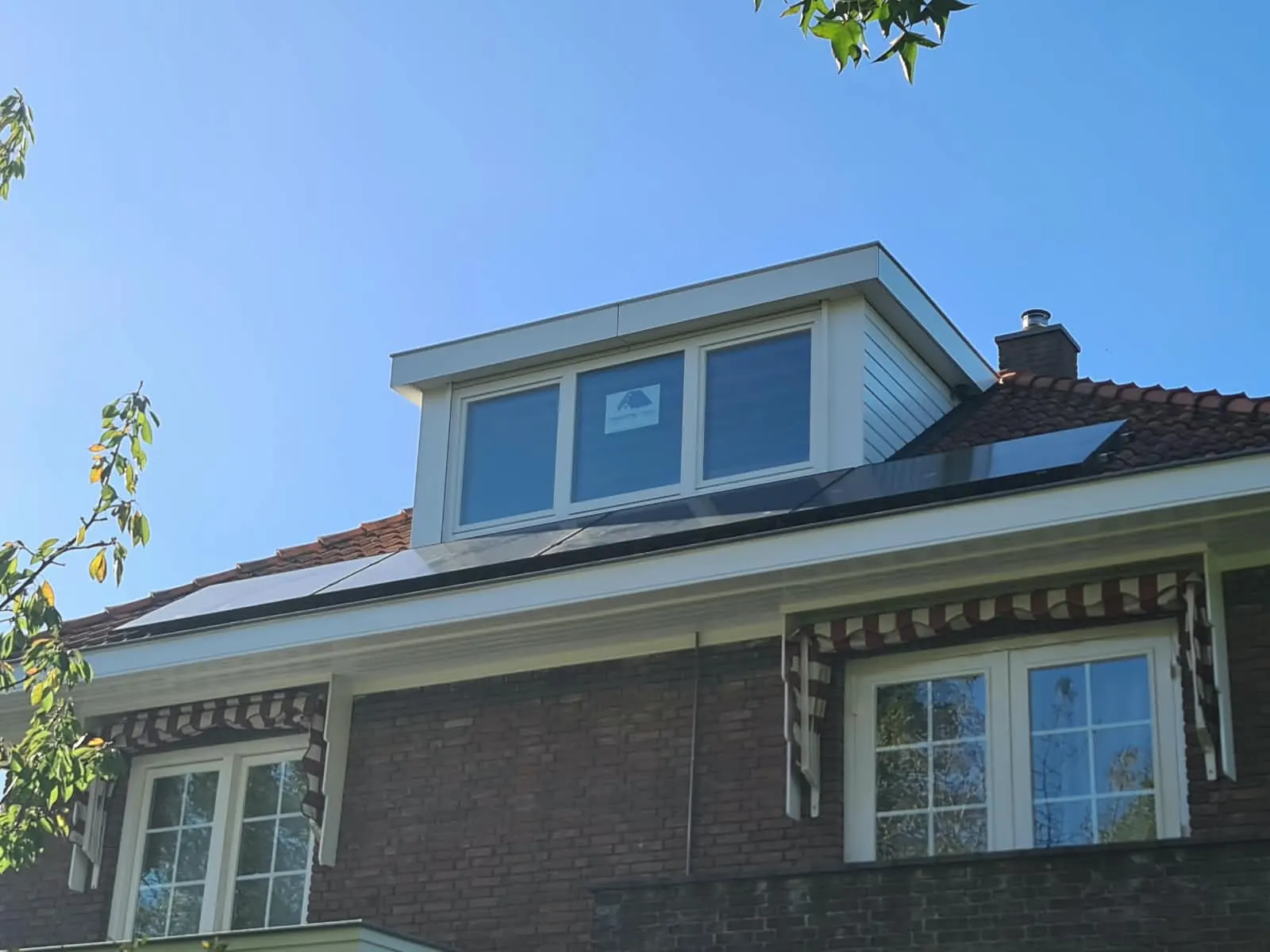 Witte dakkapel op een twee-onder-een-kapwoning